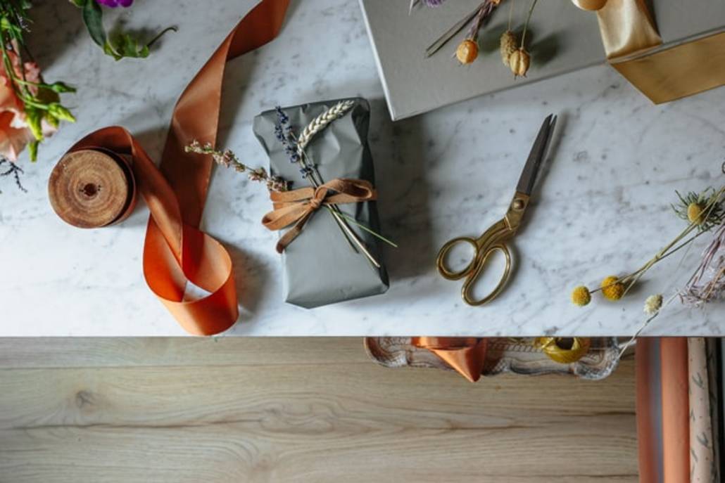auf dem Tisch liegen Schere, Geschenkpapier, Geschenke